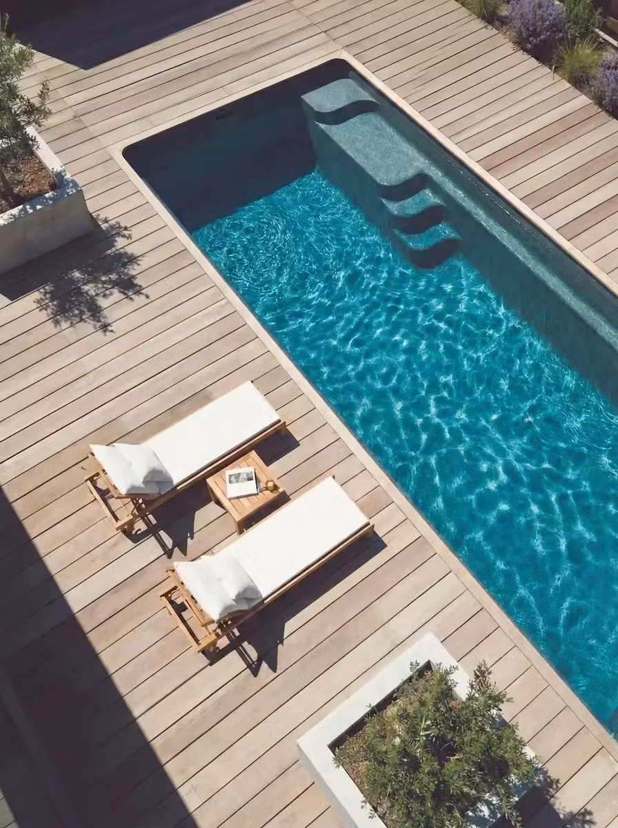 Vue aérienne du modèle Swim 6 installé à Sanary, deck en bois clair, deux transats teck et bacs plantés