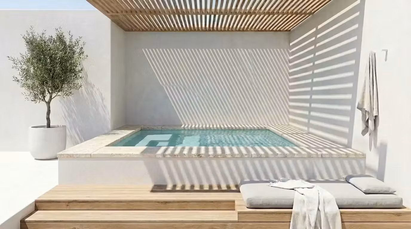 Mini-piscine surélevée bordée de pierre, olivier en pot et pergola bois projetant des ombres rythmées