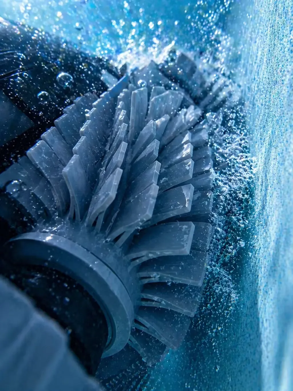 Détail rapproché de la brosse cylindrique d'un robot de nettoyage en action dans une piscine