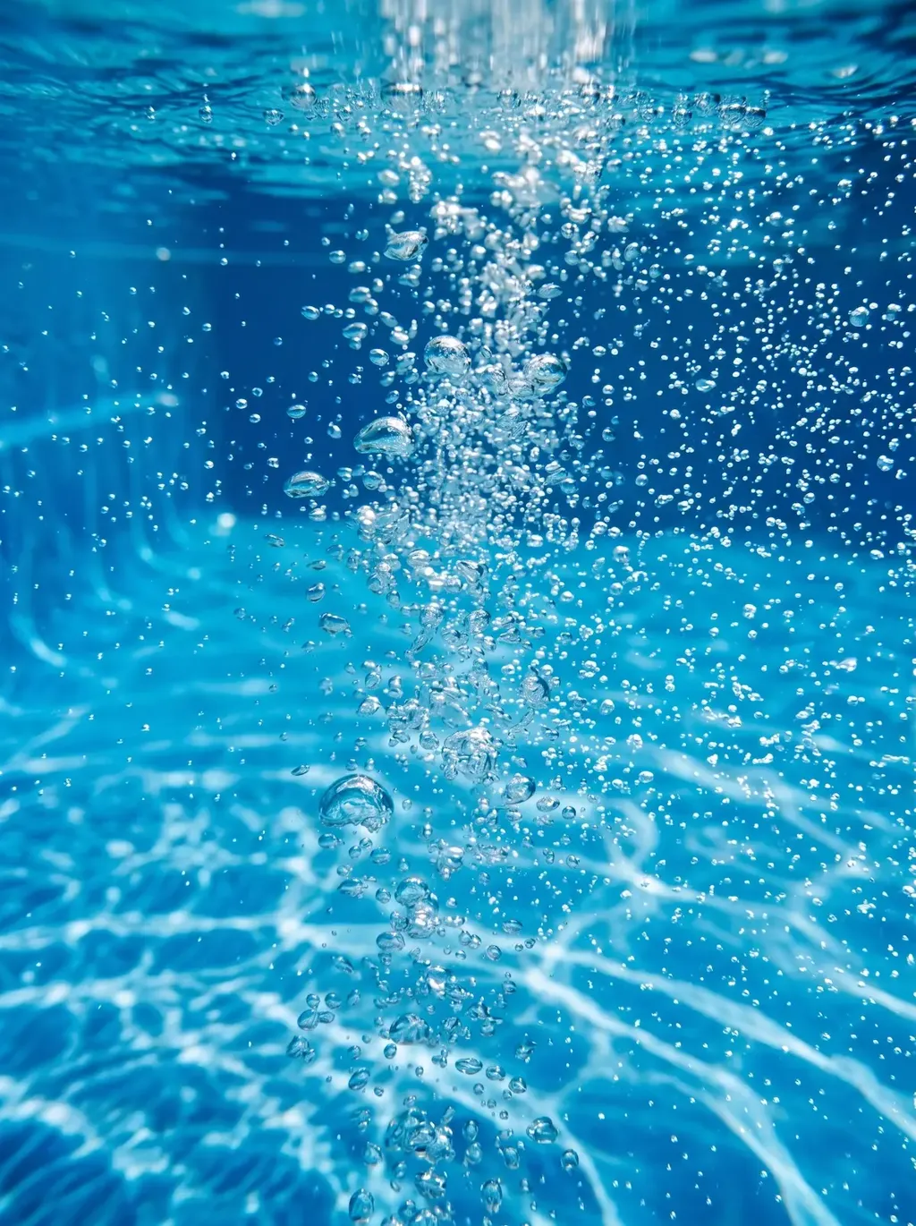 Vue sous-marine de bulles d'air remontant dans l'eau bleue d'une piscine