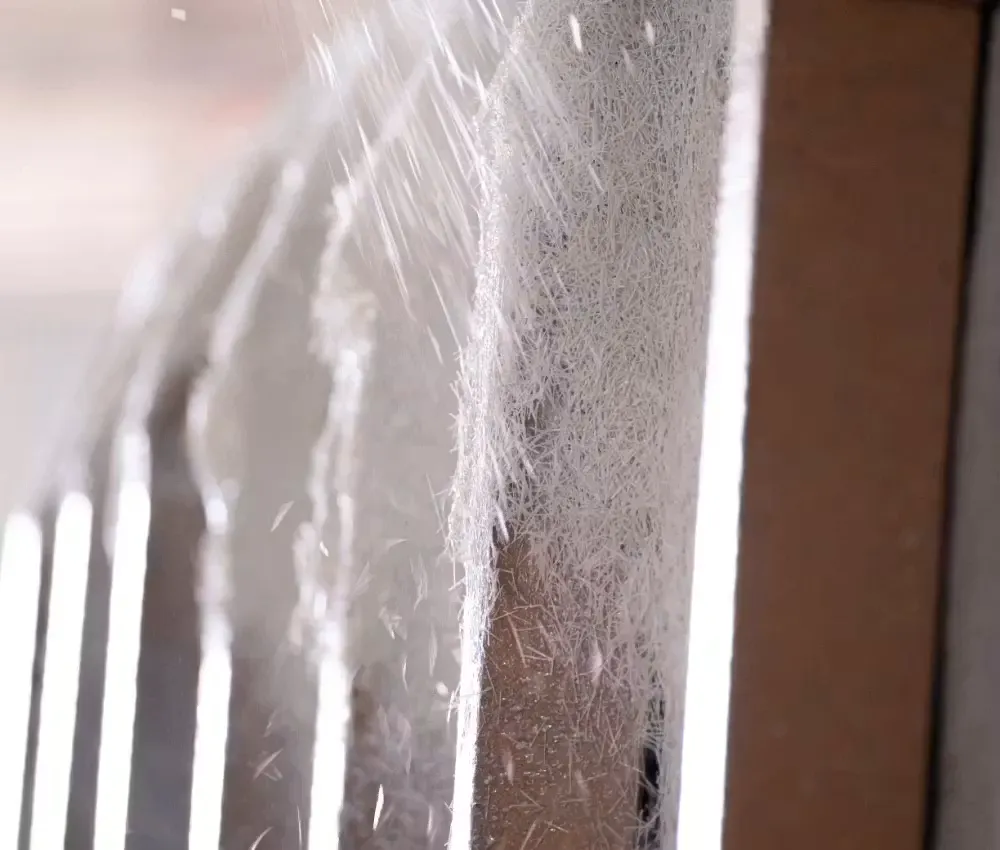 Projection de fibres de verre sur un moule lors de la fabrication d'une coque polyester